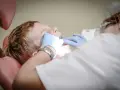 Chłopiec u dentysty, który bada jego zęby. Może to być związane z bólem podniebienia przy zębach górnych.
