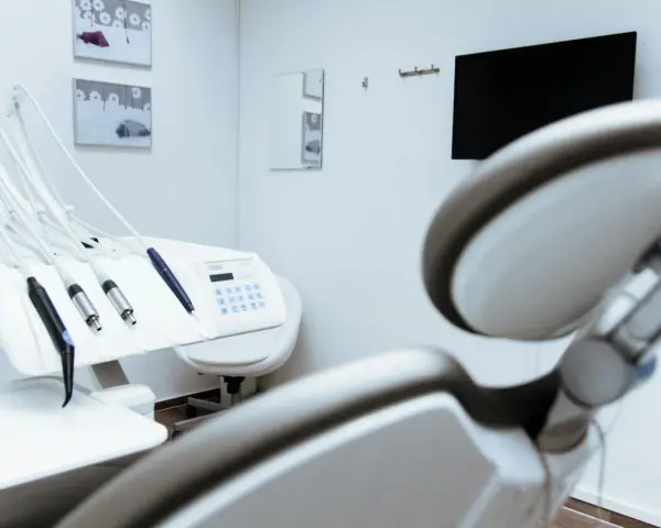 Gabinet stomatologiczny z fotelem i narzędziami. W tle monitor i lustro. Czystość i sterylność, jak po użyciu środka z chlorheksydyny diglukonianem.