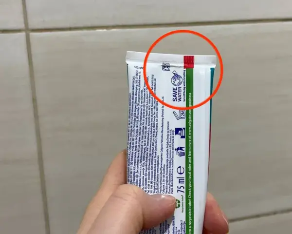 Oznaczenia past do zębów na tubce Colgate. Czerwone kółko podkreśla górną część opakowania.