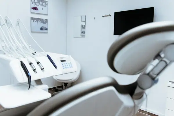 Gabinet stomatologiczny z fotelem i narzędziami. W tle monitor i lustro. Czystość i sterylność, jak po użyciu środka z chlorheksydyny diglukonianem.